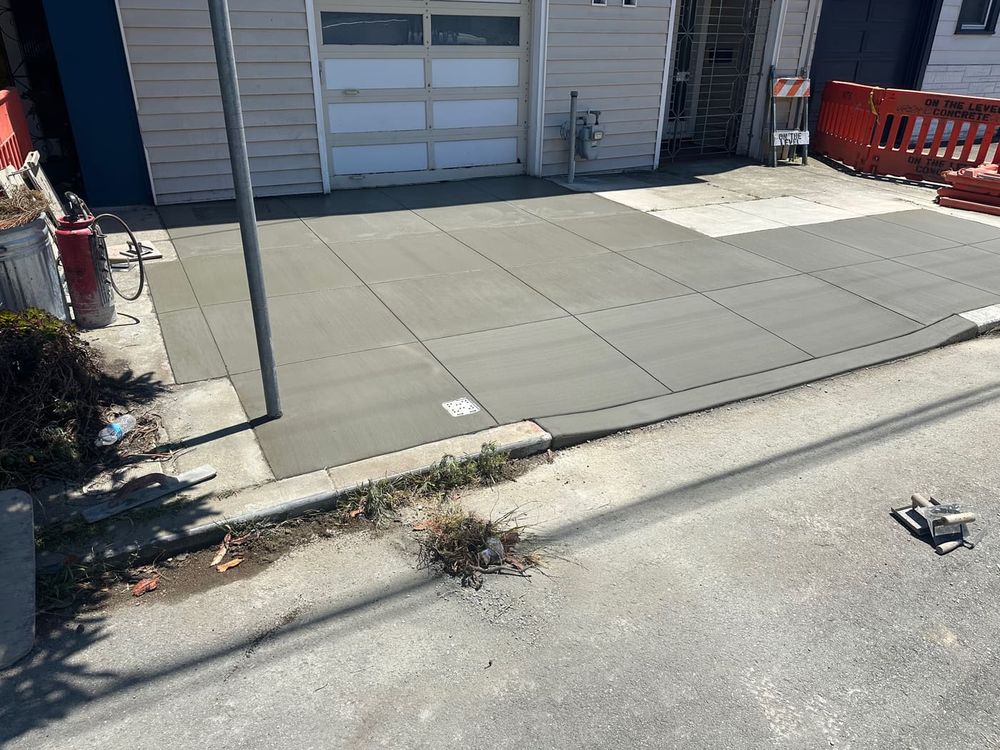 Freshly poured concrete driveway and apron in front of a garage